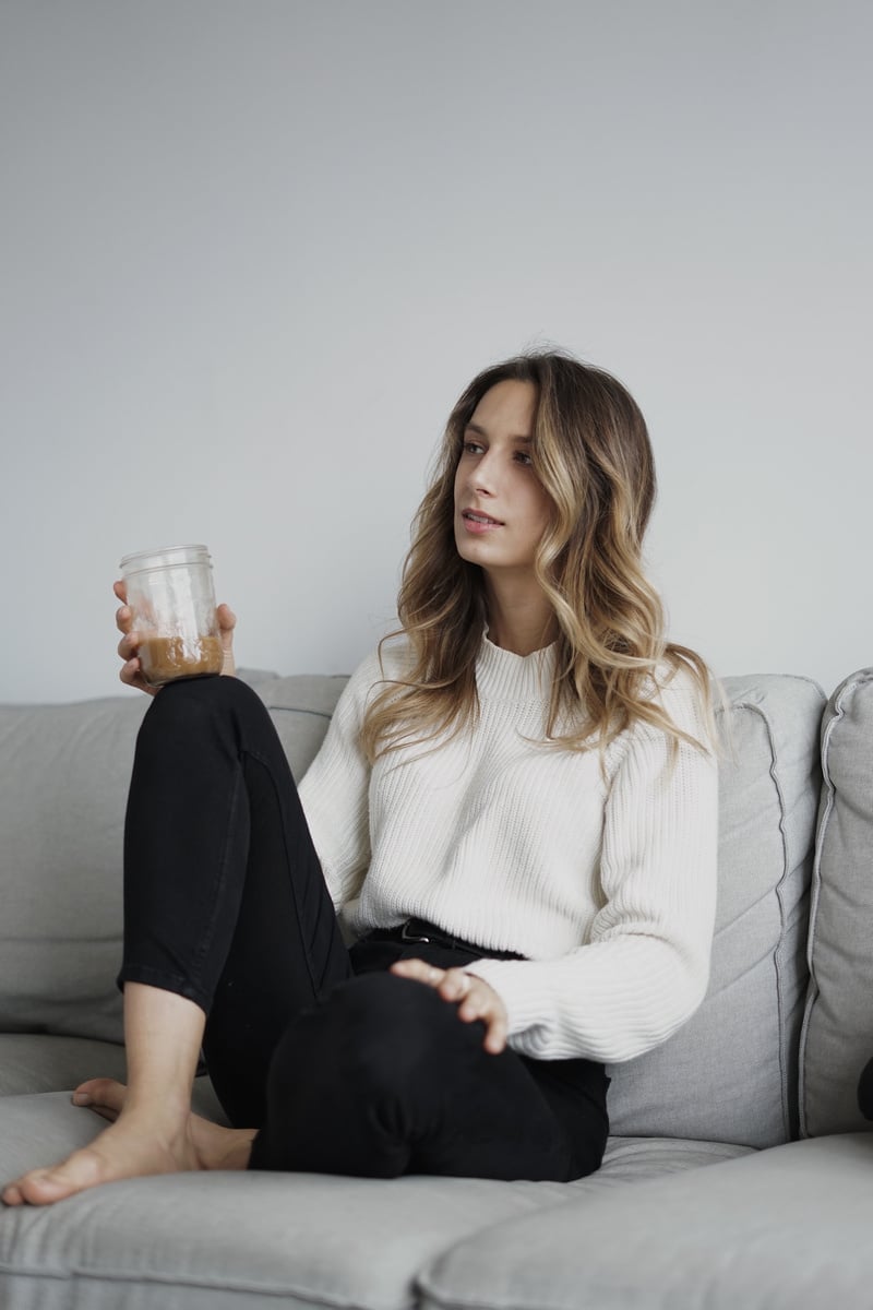 Woman in White Sweater Sitting on Gray Sofa